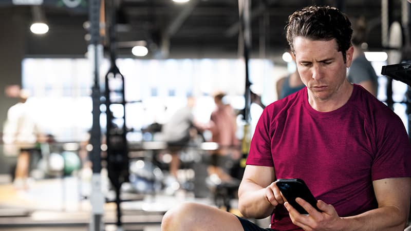 Gym coach checking CRM dashboard with member retention analytics
