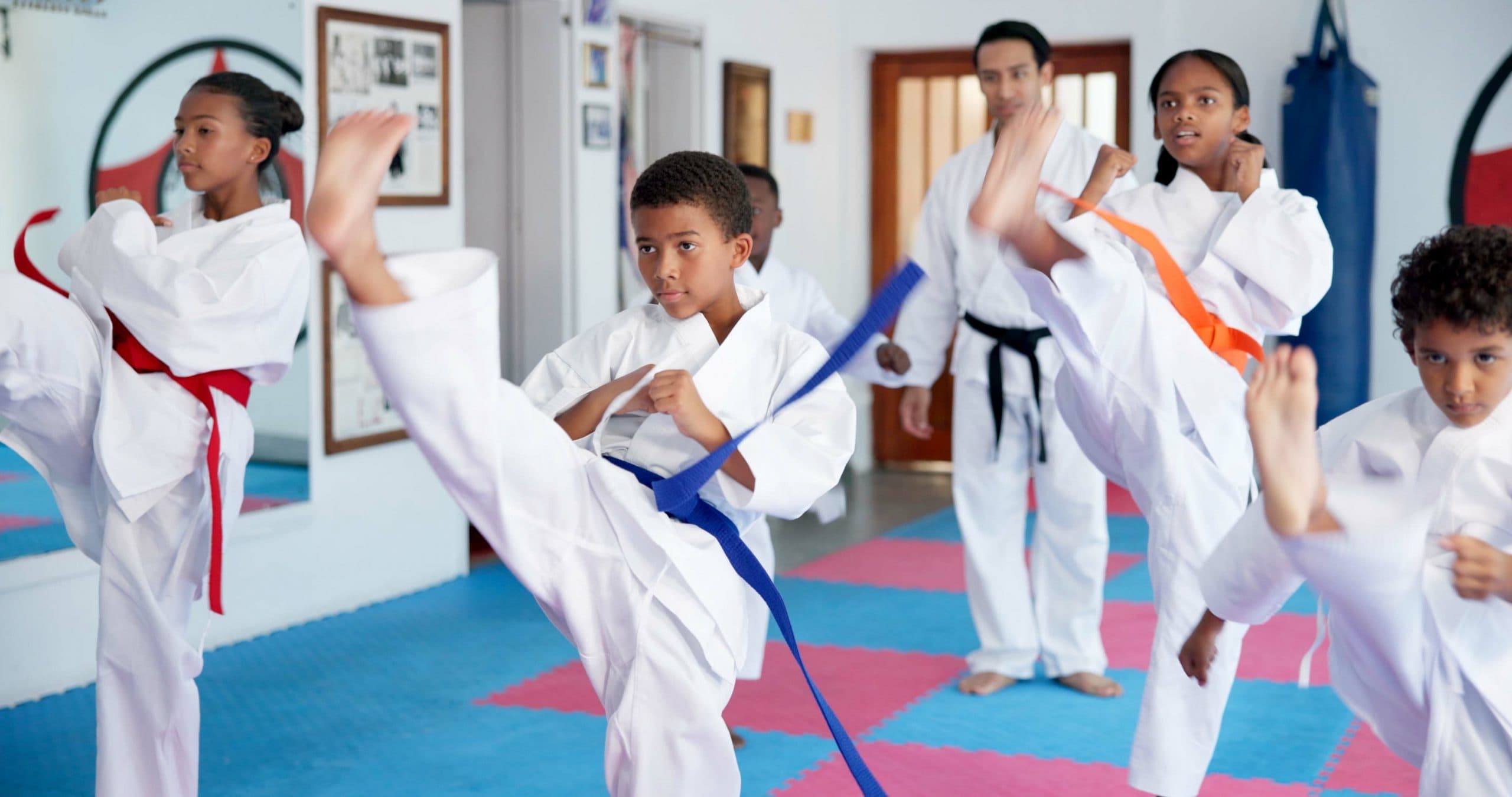 Development, fitness or growth with children and sensei in dojo for martial arts lesson or practice